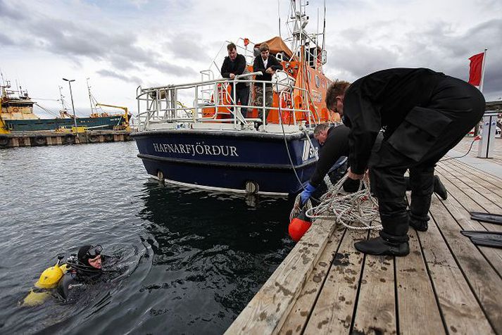 Kafarar leituðu að morðvopninu í smábátahöfninni.