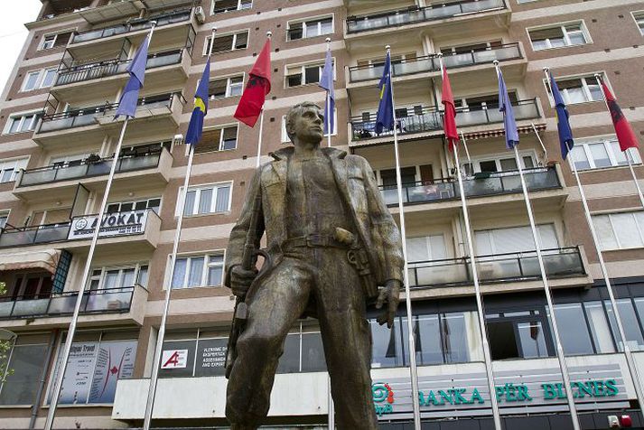 Stytta af hetju Fánar Kosovo og Albaníu blakta fyrir aftan styttu af félaga úr Frelsisher Kosovo í höfuðborginni Pristina.fréttablaðið/AP