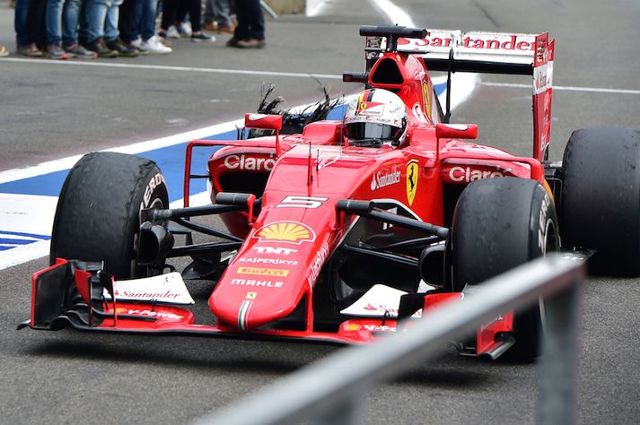 Vettel haltrar á þjónustusvæðinu til að fá ný dekk undir.