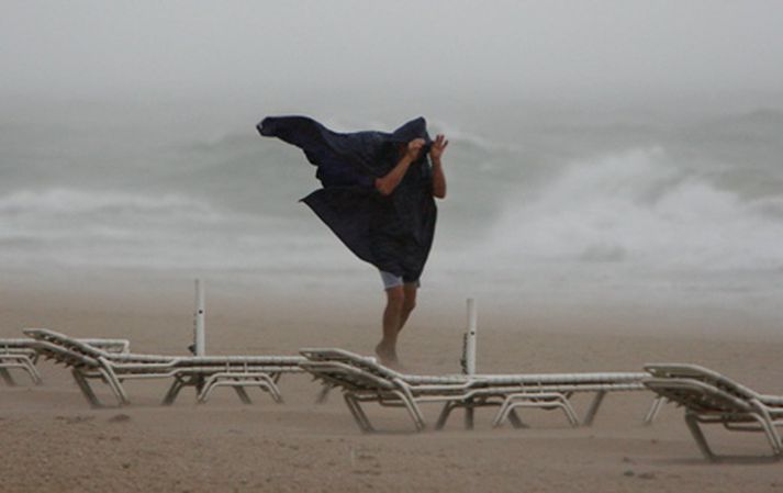Maður á göngu á ströndinni í Ft. Lauderdale þar sem Fay gekk yfir.