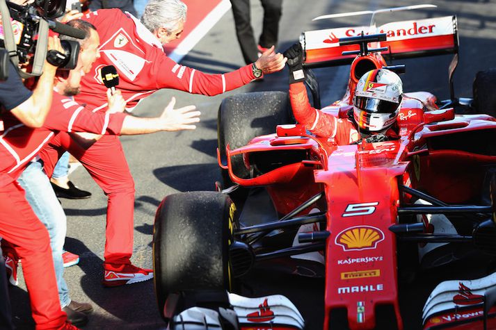 Sebastian Vettel gefur liðsstjóra Ferrari Maurizio Arrivabene háa fimmu.