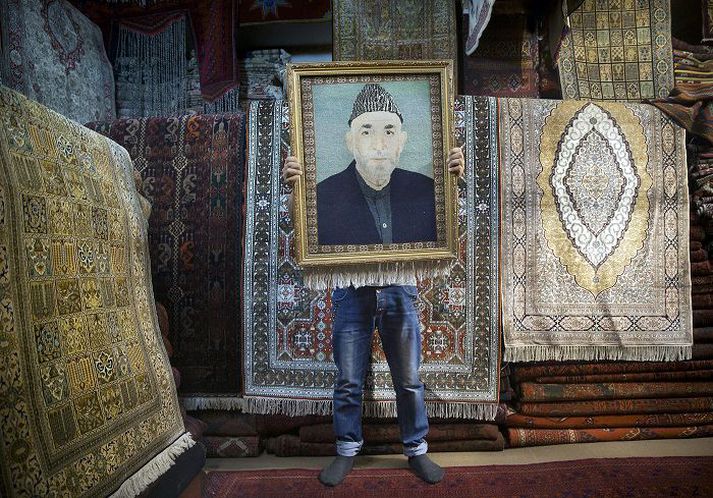 Afgani Teppasölumaður í Kabúl heldur uppi innrömmuðu teppi sem skartar brjóstmynd af Hamid Karzai, forseta landsins. Afganar ganga til forsetakosninga um helgina.