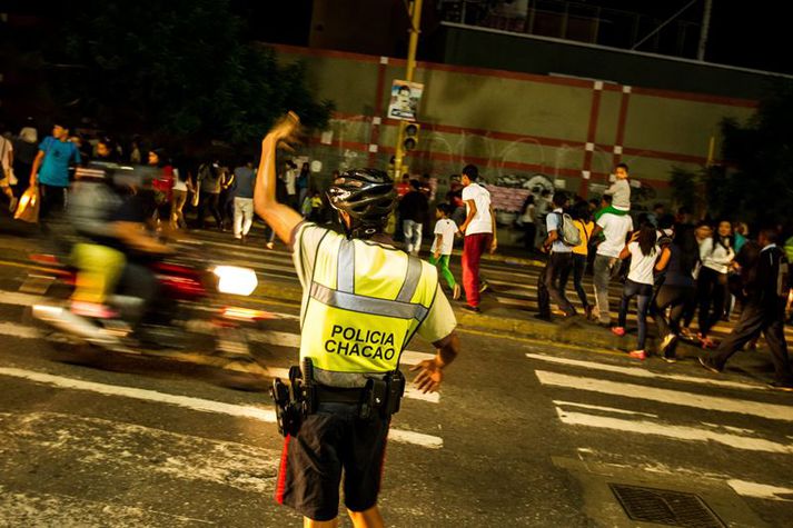 Lögreglumaður í Caracas reynir að stjórna umferðinni þar sem umferðarljósin hættu að virka.