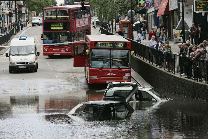 Tveir bílar mara í hálfu kafi í Wallington á Suður-Englandi. Miklar rigningar hafa verið í landinu sem hafa orsakað mikil flóð víða um landið.