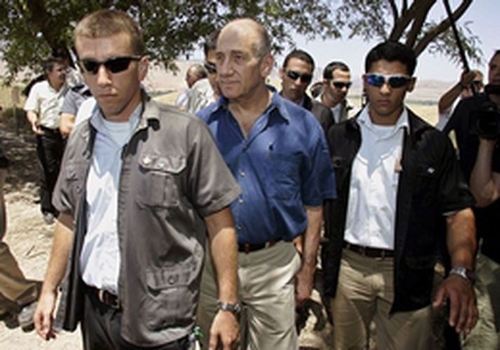 Ehud Olmert forsætisráðherra umkringdur lífvörðum við landamæri Palestínu.
