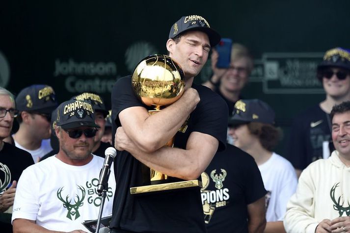 Brook Lopez faðmar hér Larry O'Brien bikarinn eftir sigur Milwaukee Bucks. Það eru samt margir að óska tvíburabróður hans til hamingju með titilinn.