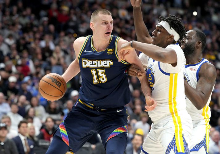 Nikola Jokic horfir í kringum sig en Kevon Looney reynir að verjast honum í leik Denver og Golden State.