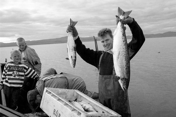 Baldvin Karel fylgist með Björgvini Guðmundssyni sýna ljósmyndara tvo nýveidda laxa. Bjarnfinnur Þorkelsson og Guðmundur Sæmundsson sýsla í bakgrunni.