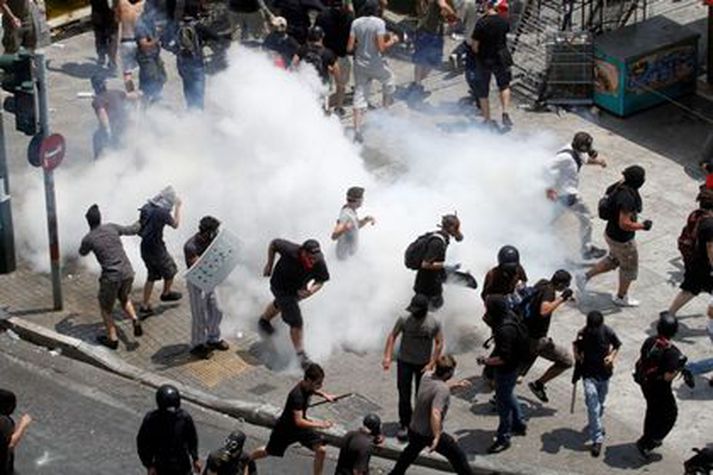 Mótmælendur flýja táragas. Myndin er tekin í Aþenu í gær.