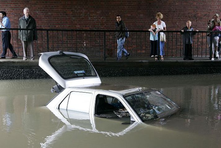 Eiganda þessa bíls í suðurhluta London er vart skemmt en hann er einn af fjölmörgum sem hafa orðið fyrir eignatjóni í flóðunum. Fréttablaðið/AP
