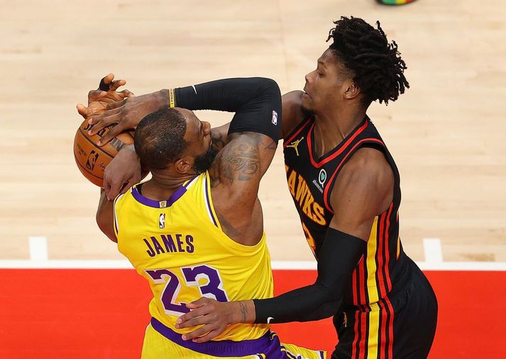 Cam Reddish brýtur á LeBron James í sigri Lakers á Hawks í nótt.