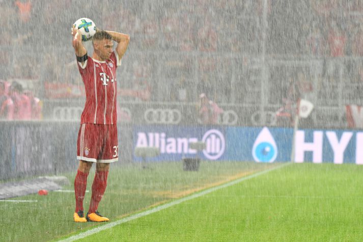 Joshua Kimmich tekur innkast fyrir Bayern í  miðju úrhellinu.