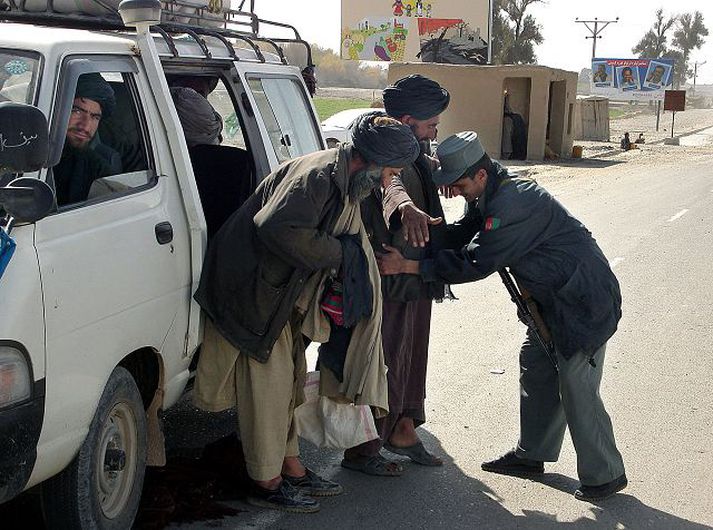 Afganskur hermaður leitar á farþegum í bifreið sem kom í gær til Lashkar Gah, höfuðstaðar í héraðinu Helmand í Afganistan þar sem talibanar hafa löngum átt skjól.