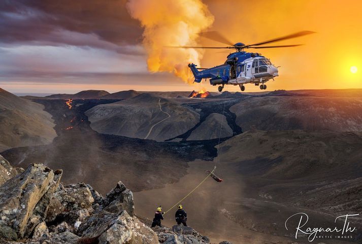 Sjúkrabörur fluttar úr þyrlu og í fjallshlíðina.