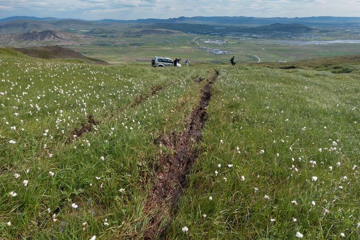 Ökumaðurinn og félagar hans halda niður Esjuna eftir að þeir festu bílinn á laugardaginn.Skemmdirnar á gróðrinum eru vel sýnilegar.