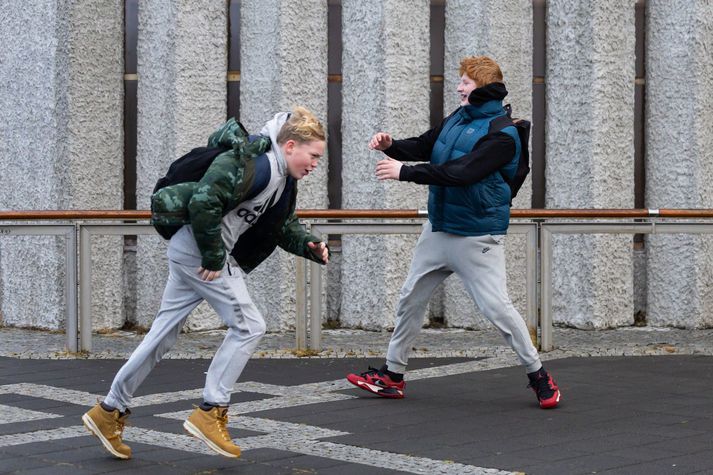 Tveir drengir leika sér að vindinum við Hallgrímskirkju.