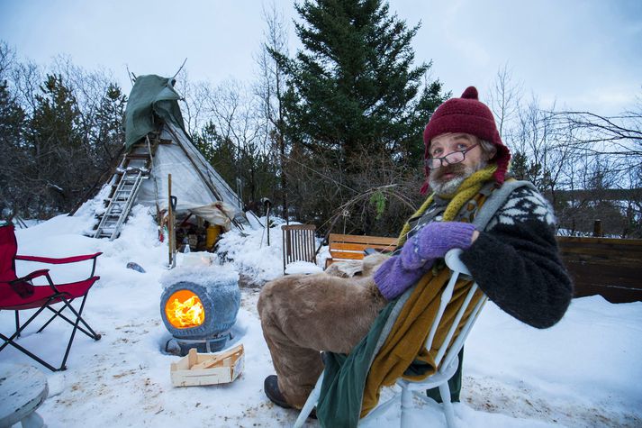 Tryggvi Hansen heggur ekki tré í skóginum. Hér situr hann við eld sem hann kveikti úr mandarínukössum.

