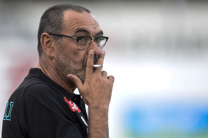 Maurizio Sarri fær sér smók. Hjá Chelsea tók hann upp á því að naga sígarettur eftir að honum var bannað að reykja á hliðarlínunni.