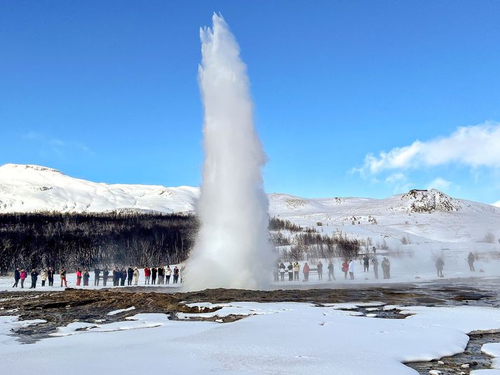 Ferðamenn fylgjast með Strokki gjósa í Haukadal.
