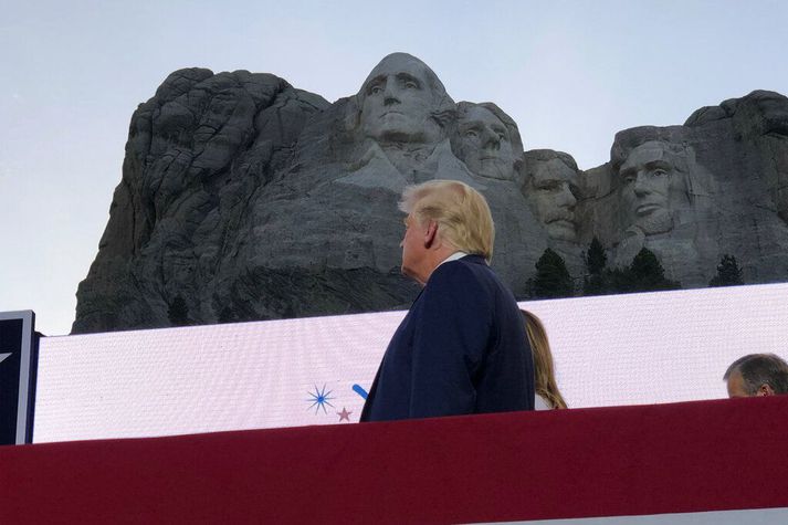 Trump á sviði við Rushmore-fjall í gær. Í fjallið eru grafin andlit fjögurra fyrrverandi forseta Bandaríkjanna. Frá vinstri: George Washington, Thomas Jefferson, Teddy Roosevelt og Abraham Lincoln. Nýlegir atburðir í Bandaríkjunum hafa látið marga landsmenn endurskoða álit sitt á leiðtogum fortíðarinnar, þar á meðal á Washington sem var þrælahaldari.