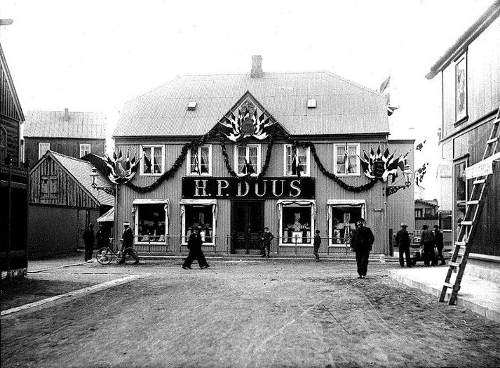 1907   Byggingar, krambúð   Duusverslun, Aðalstræti 2. Fólk á gangi.                                                H.P Duus. Dönsk áhrif