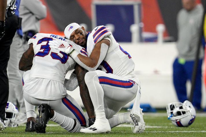 Leikmenn Buffalo Bills. þeir Siran Neal (33) og Nyheim Hines hughreysta hvorn annan á meðan verið er að lífga við liðsfélaga þeirra Damar Hamlin í leiknum á móti Cincinnati Bengals.