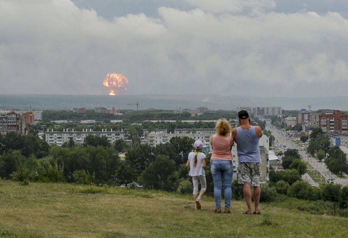 Fjölskylda fylgist með sprengingu í herstöð í Síberíu á mánudag. Annað mannskætt slys varð á vopnatilraunasvæði rússneska hersins í dag.