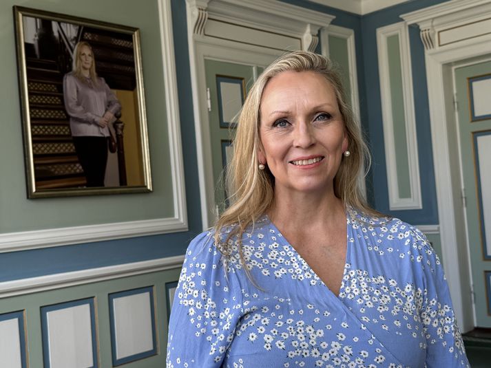 Unnur Brá Konráðsdóttir, fyrrverandi forseti Alþingis, ásamt málverki af sjálfri sér á Alþingi.