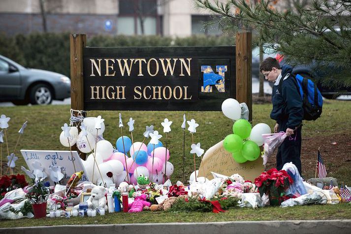 Látinna minnst Skólanemandi í Newtown leggur blómvönd niður fyrir utan Sandy Hook-barnaskólann, þar sem hinn tvítugi Adam Lanza myrti 20 börn á leikskólaaldri, sex konur, þar á meðal móður sína, og svipti svo sjálfan sig lífi.	 nordicphotos/AFP