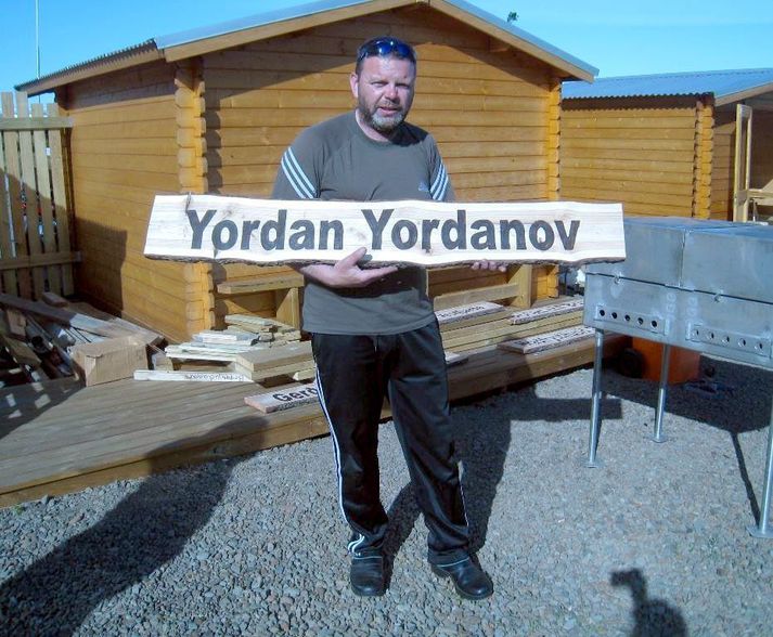 Yordan Yordanov sést hér halda á skiltinu sem hangir í Raggagarði, skemmtigarði í Súðavík. Hann er einn styrktaraðila garðsins.