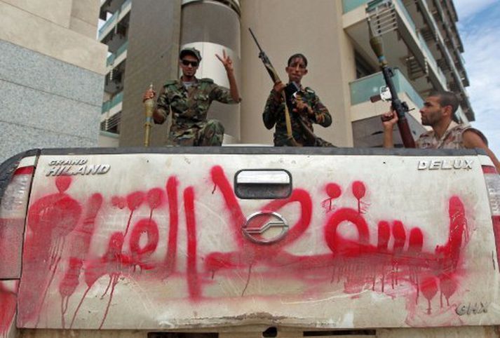 Orrustumenn byltingarhersins. Á bílnum stendur: „Gaddafi mun falla.“