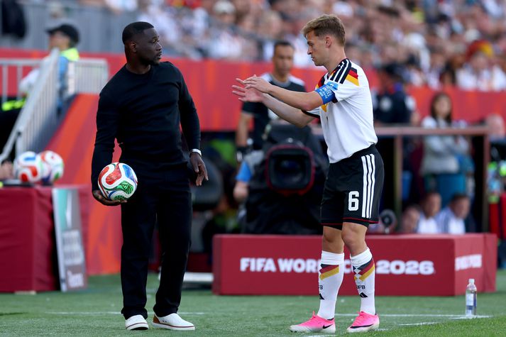 Emerse Faé, þjálfari Fílabeinsstrandarinnar, heldur hér á bolta sem Þjóðverjinn Joshua Kimmich vill endilega koma sem fyrst í leik á ný.