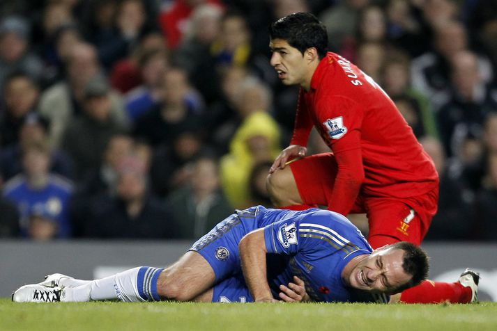 John Terry, fyrirliði Chelsea, sárþjáður eftir tæklingu Suarez.