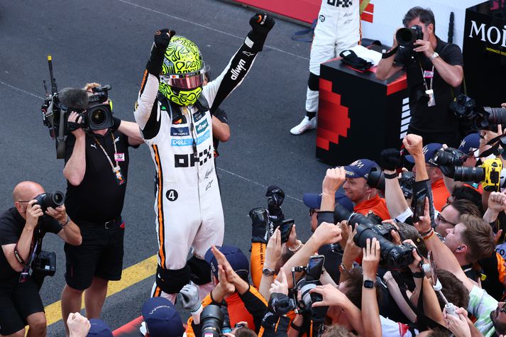 Lando Norris fagnar eftir kappaksturinn í Mónakó í dag.