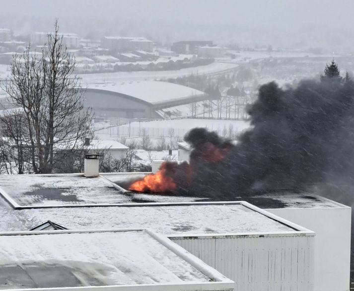 Svartan reyk lagði frá þaki hússins. 