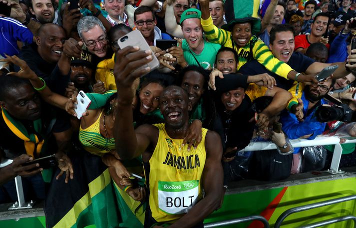 Usain Bolt fagnar sigri með sínu fólki frá Jamaíka í nótt.