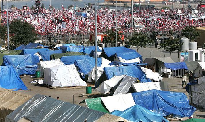 Handan við tjaldbúðir stjórnarandstæðinga í miðborg Beirút má sjá þúsundir stuðningsmanna stjórnarinnar á útifundi í gær.