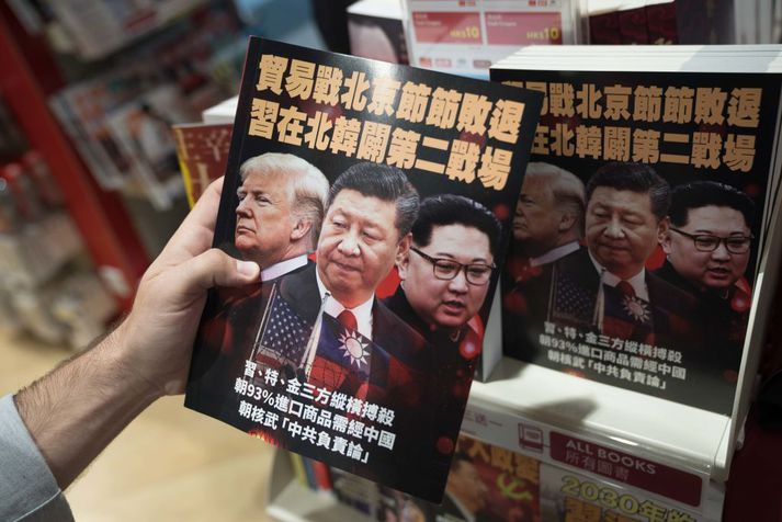 Donald Trump, forseti Bandaríkjanna, Xi Jinping, forseti Kína, og Kim Jong-un, æðsti leiðtogi Norður-Kóreu á forsíðu bókar sem var til sölu á flugvellinum í Hong Kong.