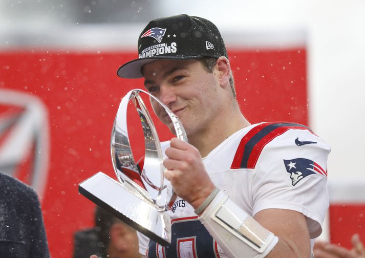 Drake Maye hélt á bikarnum fyrir sigurinn í Ameríkudeildinni í vinstri hendi af því að hann meiddi sig á kasthendinni í leiknum.