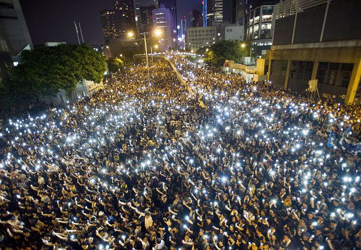 Mörg hundruð mótmælendur kveiktu á símunum sínum í fjármálahverfi Hong Kong.