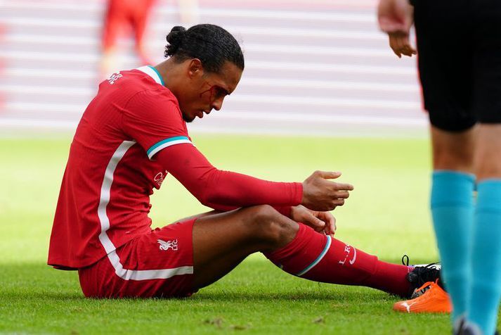 Virgil van Dijk situr í grasinu eftir að hafa fengið skurð á andlitið í gær.