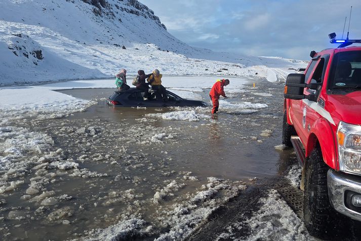 Ferðamenn á ferð austan Stykkishólms við Straumsfell, lentu út af veginum í miklu vatni sem flæddi inn á veginn. Bíllinn flaut upp og útaf. Fólkið leitaði upp á þak og beið þar björgunar