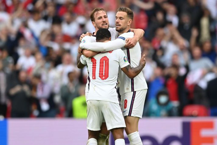 Jordan Henderson faðmar markaskorarana Raheem Sterling og Harry Kane í leikslok.