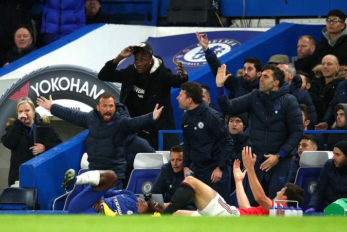 Harry Maguire og Michy Batshuayi liggja í grasinu eftir atvikið en bekkurinn hjá Chelsea trompast.