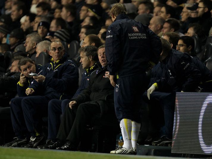 Eiður Smári Guðjohnsen hitar upp á hliðarlínunni fyrir leik með Tottenham.