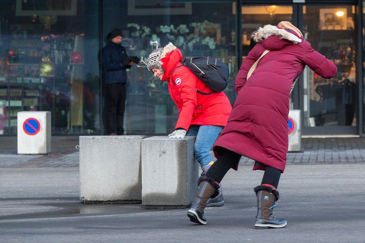 Hér má sjá ferðamenn við Hörpu í einu óveðrinu. Stormi er spáð á miðvikudag og veðurfræðingur segir að fólk eigi ekki að gera ráð fyrir að komast ferða sinna.