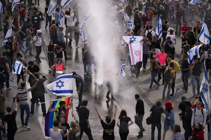 Lögregla beitti háþrýstidælum á mótmælendur í Tel Aviv á fimmtudag. Mótmæli héldu áfram um helgina.