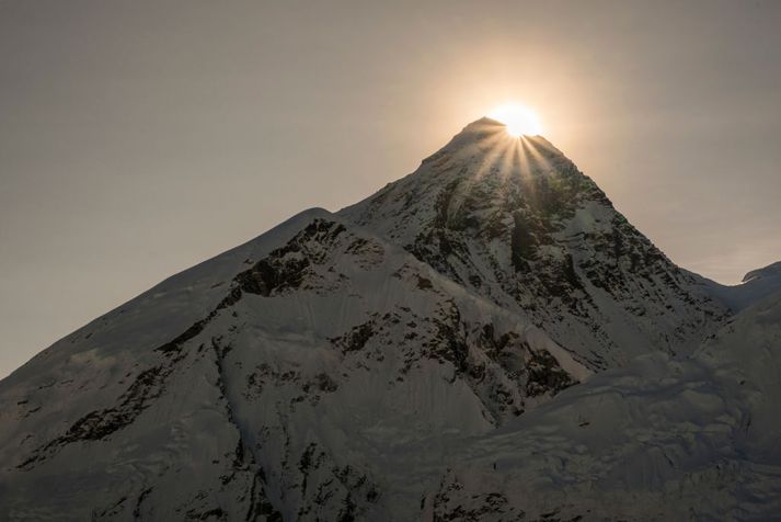 Sólin gægist á bak við tind Everest-fjalls. Göngufólk skilur eftir mikið af rusli á fjallinu og þá er þar fjöldi líka fjallgöngumanna sem hafa farist á leiðinni.