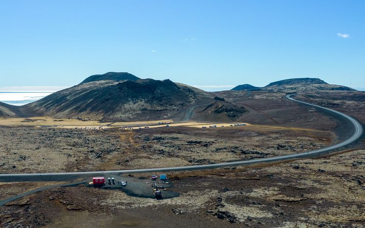 Frá upphafsstað aðalgönguleiðarinnar við Suðurstrandarveg. Fjær sjást bráðabirgðabílastæði á túnum undir Festarfjalli. Hugmyndir eru um að leggja ný bílastæði nær jarðeldunum.