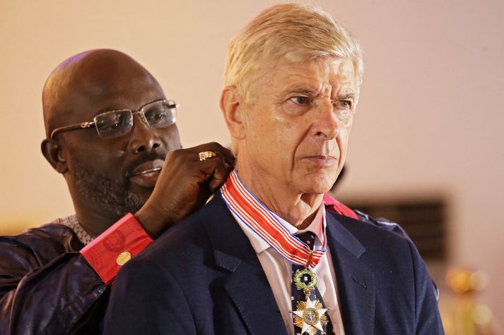 Arsène Wenger fær hér orðuna frá George Weah.